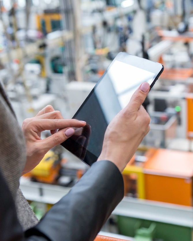 Businesswoman using digital tablet to check inventory in futuristic factory